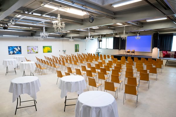 Halle 1 mit Rundtischen und Stuhlreihen